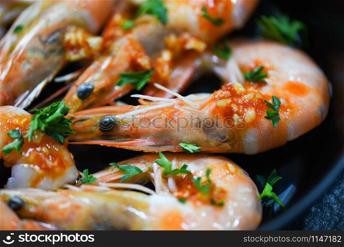 Seafood plate with shrimps prawns ocean gourmet dinner seafood cooked with sauce herbs and spices on pan background / Close up shellfish shrimp boiled
