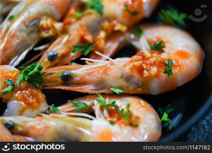 Seafood plate with shrimps prawns ocean gourmet dinner seafood cooked with sauce herbs and spices on pan background / Close up shellfish shrimp boiled