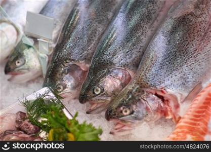 seafood, sale and food concept - chilled fresh fish on ice at grocery stall