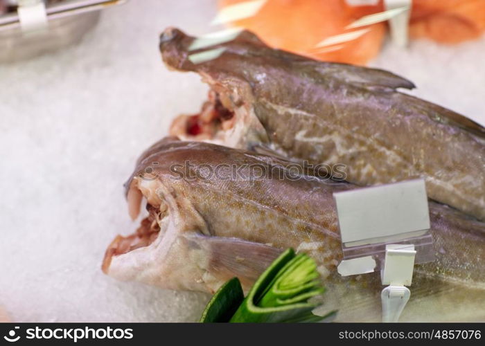 seafood, sale and food concept - chilled fresh fish on ice at grocery stall