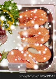 seafood, sale and food concept - chilled fresh salmon fish fillet in metal tray on ice at grocery store over snow. salmon fish fillet in metal tray on ice at grocery
