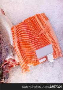 seafood, sale and food concept - chilled fresh salmon fish fillet on ice at grocery store