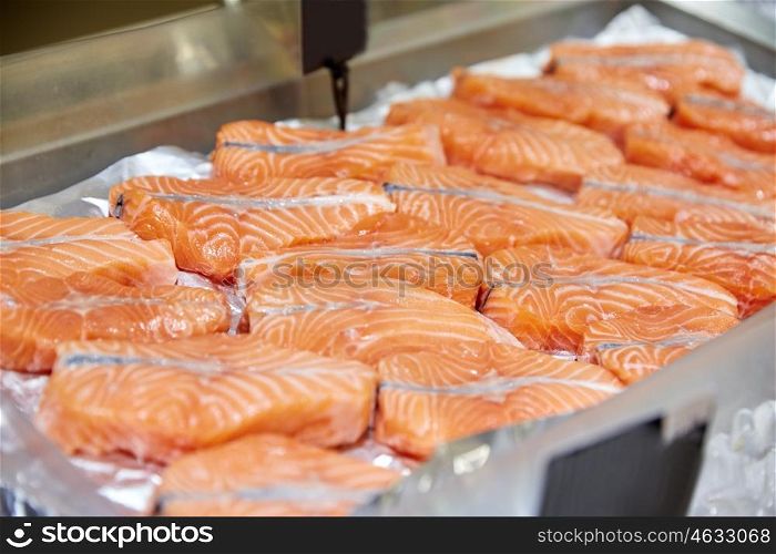 seafood, sale and food concept - salmon fish at market stall