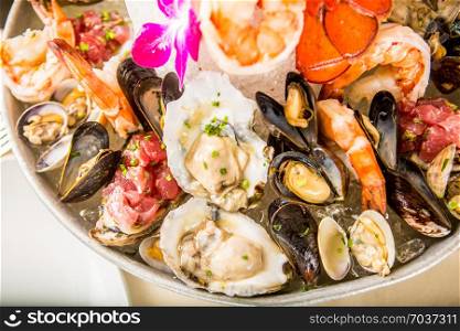 Seafood set with Lobsters, Clams, Fish, Blue Clabs, Big Prawns, Mussels and Calamari Squids with pieces of lemon & vetgetables