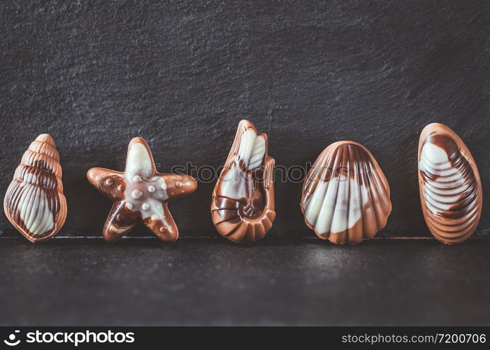 Seafood-shaped chocolate candies on stone board