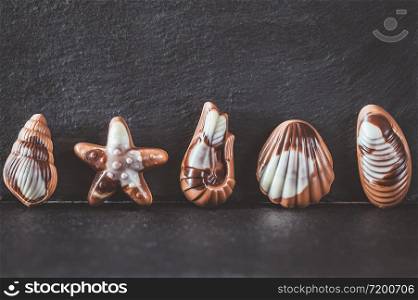 Seafood-shaped chocolate candies on stone board
