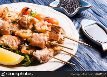 Seafood shashlik - slices of salmon and shrimps on a wooden skewers