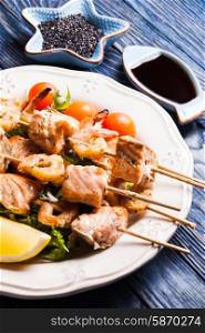 Seafood shashlik - slices of salmon and shrimps on a wooden skewers