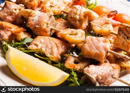 Seafood shashlik - slices of salmon and shrimps on a wooden skewers. The Seafood shashlik