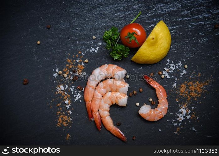 Seafood shrimp on top view / Shellfish fresh shrimps prawns ocean gourmet with tomato lemon green parsley herbs and spices on dark background