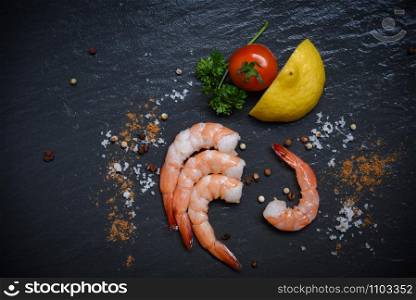 Seafood shrimp on top view / Shellfish fresh shrimps prawns ocean gourmet with tomato lemon green parsley herbs and spices on dark background