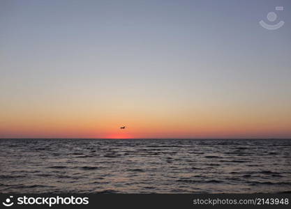 seagulls fly on golden sunset or sunrise at the deep dark ocean. aerial view of sundown and up to the sea. yellow and orange colorful sky. romantic beautiful sky in the spring season. seagulls fly on golden sunset or sunrise at the deep dark ocean. aerial view of sundown and up to the sea. yellow and orange colorful sky. romantic beautiful sky in the spring season.