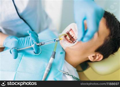 Seal installation process, pediatric dentistry, children stomatology. Female dentist works with little boy in dental clinic. Seal installation process, children stomatology