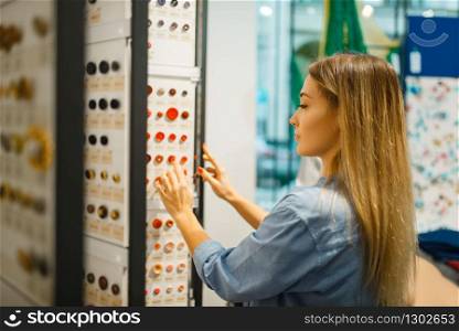 Seamstress buying buttons in textile shop. Woman choosing tools for sewing, female tailor in store, dressmaker. Seamstress buying buttons in textile shop