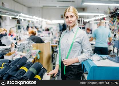 Seamstress create black threads on overlock machine, sewing material. Tailoring or dressmaking on garment factory. Seamstress create threads on overlock machine