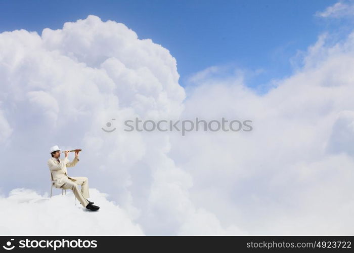 Searching for future perspectives. Businessman in white suit and hat sitting in chair and looking in spyglass