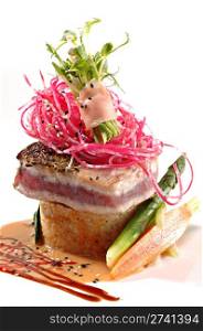 Seared ahi tuna, beet slaw & ginger wrapped sprouts served over rice with a ginger sauce on a white plate