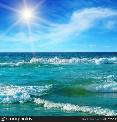 Seascape and sun on blue sky background.