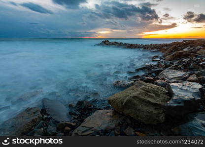 Seascape at sunset, waves roll ashore