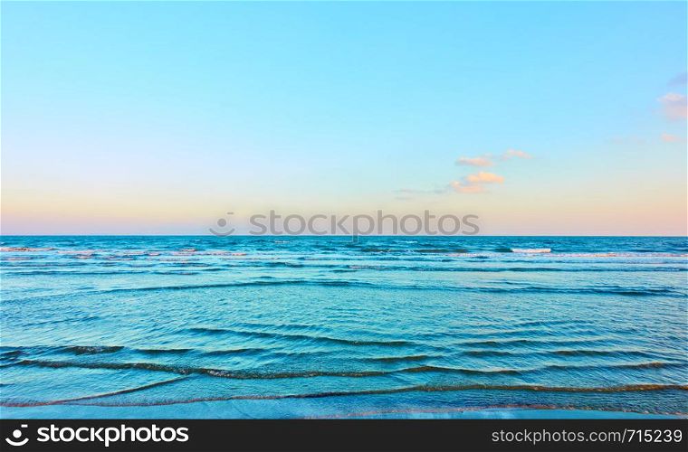 Seascape in the early evening with sea horizon and almost clear blue sky - Background