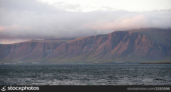 Seascape, ocean and cloud topped cliffs in evening