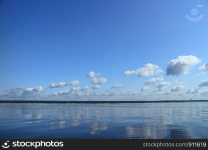 seascape, sea reflects blue sky with clouds