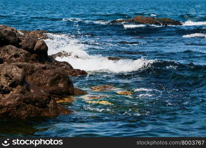 Seascape, waves rolled on large rocks sticking out of the water