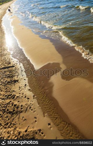 Seaside landscapes concept. View from top on sea water and sandy beach, sunny day. View from top on sea water and beach