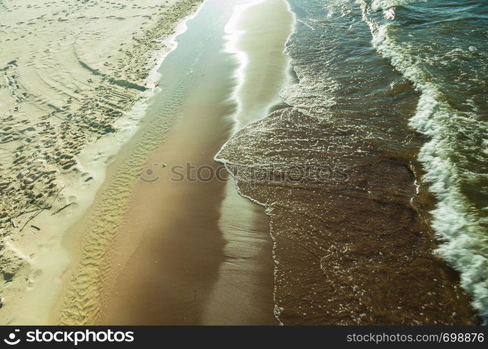 Seaside landscapes concept. View from top on sea water and sandy beach, sunny day. View from top on sea water and beach