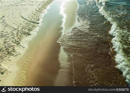 Seaside landscapes concept. View from top on sea water and sandy beach, sunny day. View from top on sea water and beach