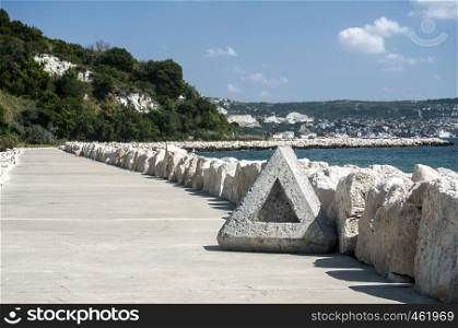 Seaside promenade with white stones on clear sunny summer day