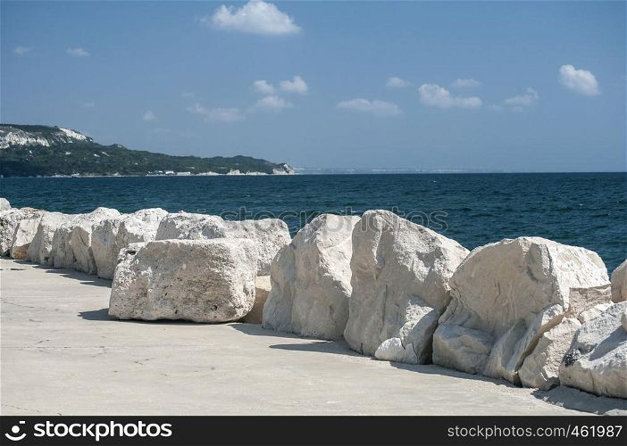 Seaside promenade with white stones on clear sunny summer day
