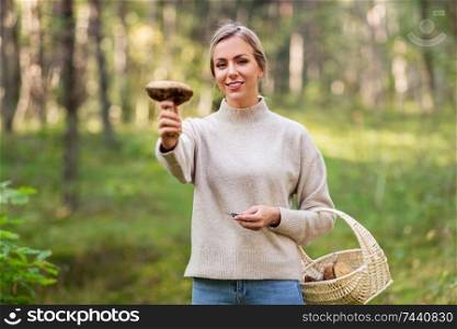 season and leisure people concept - young woman with basket and mushroom in autumn forest. young woman with mushroom in autumn forest