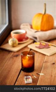 season and objects concept - candle and matches in matchbox on window sill in autumn. candle and matches on window sill in autumn