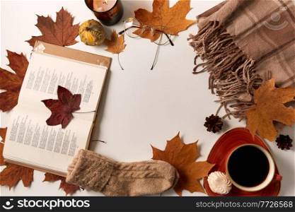 season and objects concept - open book, cup of coffee, meringue, wool warm socks, plaid and maple leaves on white background. book, coffee, socks, blanket and autumn leaves