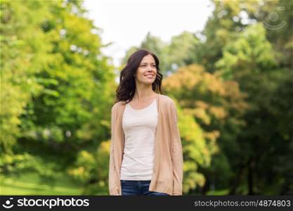 season and people concept - beautiful happy young woman in summer park. beautiful happy young woman in summer park