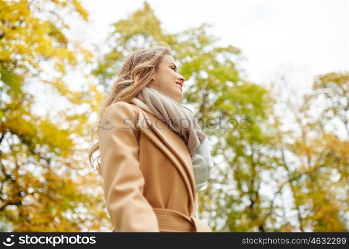 season and people concept - beautiful happy young woman smiling in autumn park. beautiful happy young woman smiling in autumn park