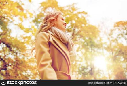 season and people concept - beautiful happy young woman smiling in autumn park. beautiful happy young woman smiling in autumn park
