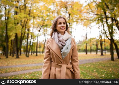 season and people concept - beautiful happy young woman walking in autumn park. beautiful happy young woman walking in autumn park