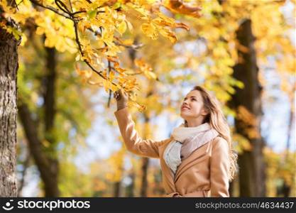 season and people concept - beautiful happy young woman walking in autumn park. beautiful happy young woman walking in autumn park