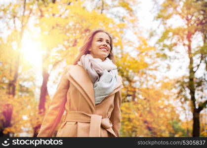 season and people concept - beautiful happy young woman walking in autumn park. beautiful happy young woman walking in autumn park