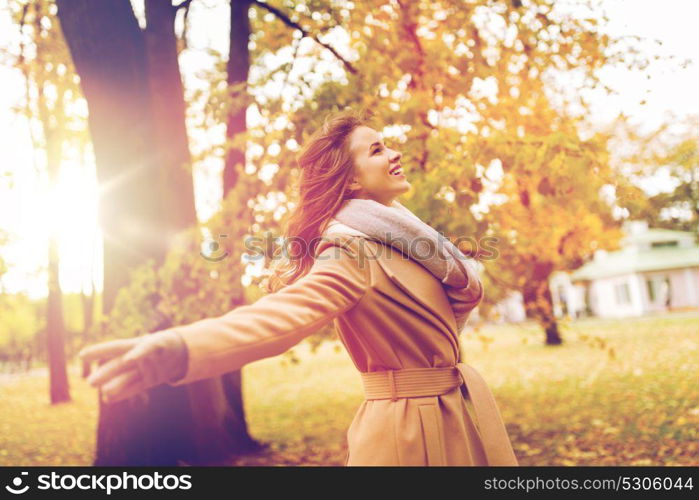 season and people concept - beautiful happy young woman walking in autumn park. beautiful happy young woman walking in autumn park