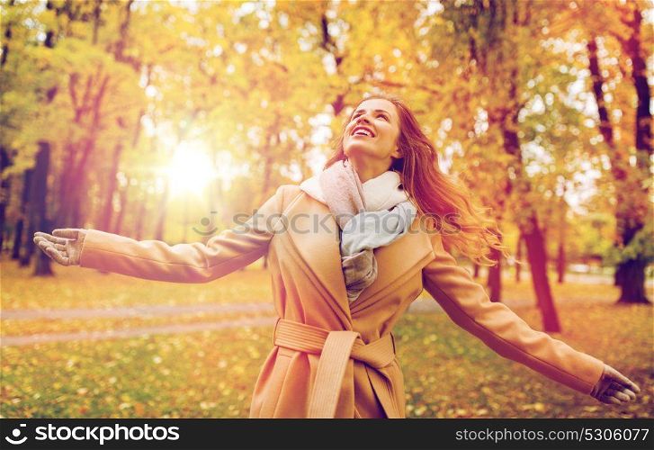season and people concept - beautiful happy young woman walking in autumn park. beautiful happy young woman walking in autumn park