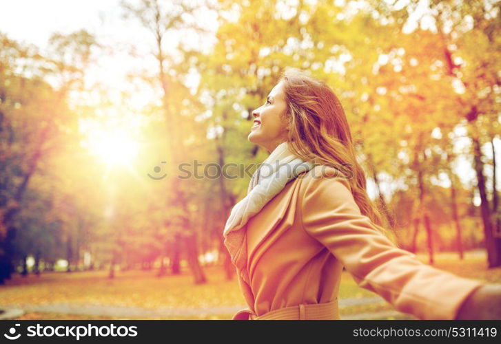 season and people concept - beautiful happy young woman walking in autumn park. beautiful happy young woman walking in autumn park