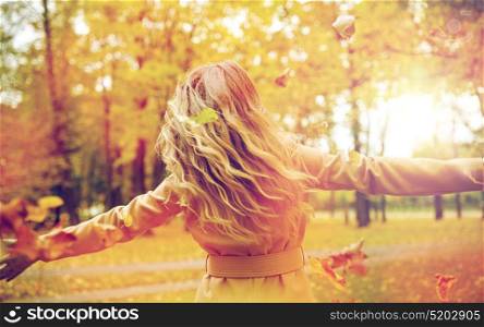 season and people concept - happy young woman having fun with leaves in autumn park. happy woman having fun with leaves in autumn park