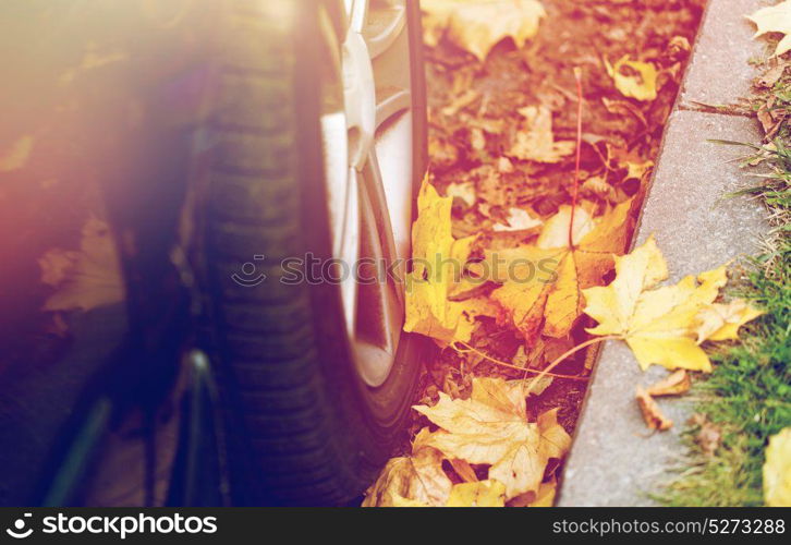 season and transport concept - close up of car wheel and autumn leaves. close up of car wheel and autumn leaves