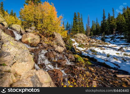 Season changing, first snow and autumn aspen trees in Rocky Mountain National Park, Colorado, USA.