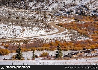 Season changing, first snow and autumn trees along highway in Colorado, USA.