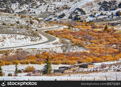 Season changing, first snow and autumn trees along highway in Colorado, USA. 