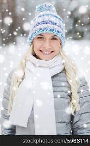 season, christmas and people concept - happy smiling young woman in winter forest